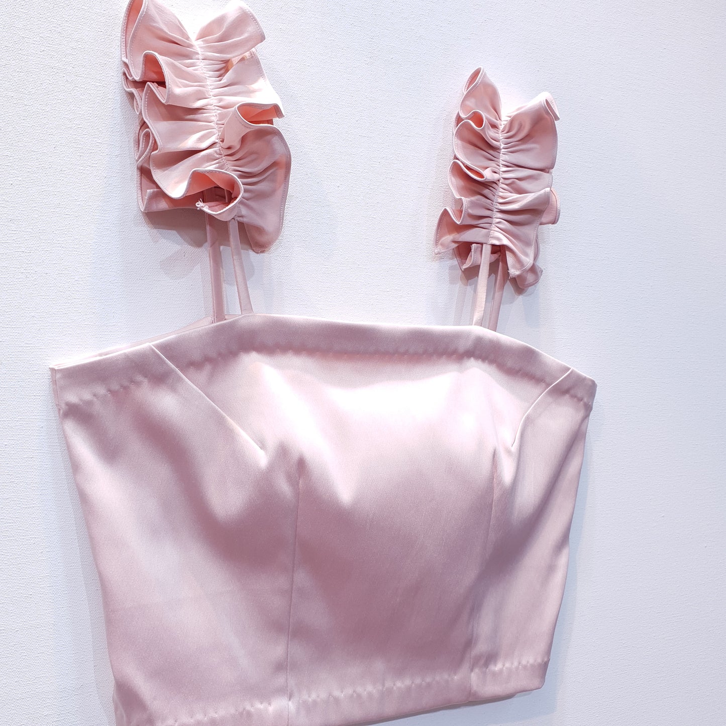 Pink duchess satin top with ruffle straps on a white background