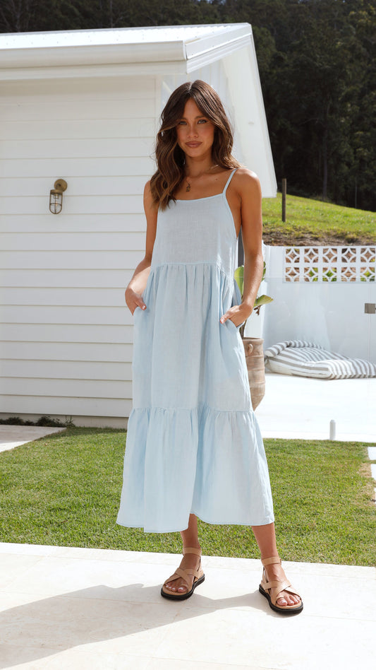 Light blue linen midi dress with tiered hem, thin straps, and side pockets